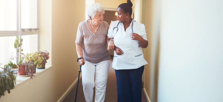 nurse and elderly woman walking